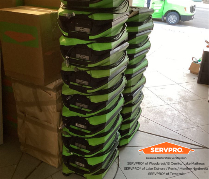 airmovers in a garage stacked up with SERVPRO boxes behind them
