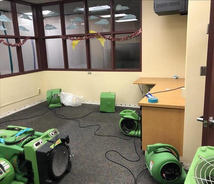 water loss in office at local elementary school. office cleared out and fans placed for drying